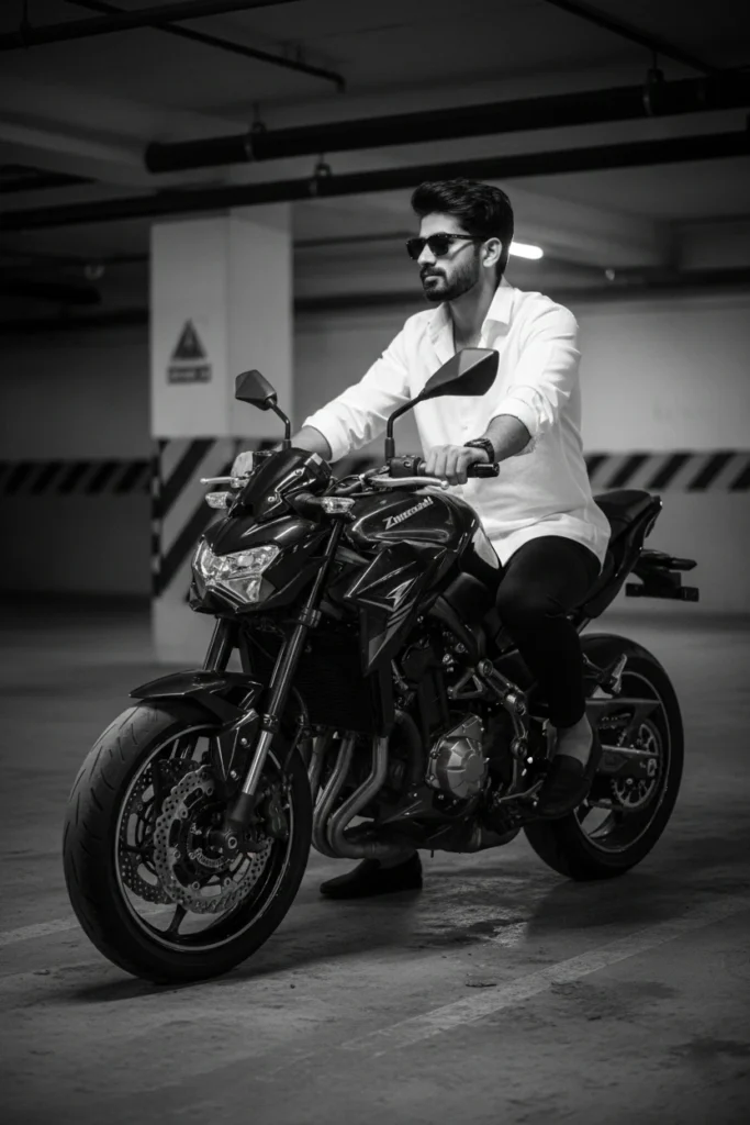 A stylish man in a white shirt and sunglasses riding a sports bike, captured in a black and white motorcycle photography style inside a garage.